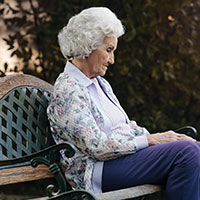 photo of a senior sitting on a bench alone